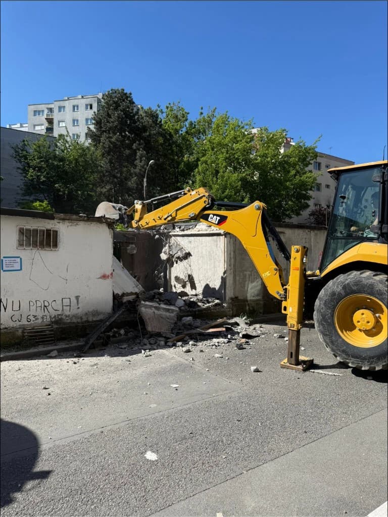 Buldoexcavator CAT la demolare structură beton